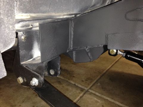 1987 Suzuki Samurai - This image shows a close-up view of an anti-wrap bar being installed on a vehicle's frame.