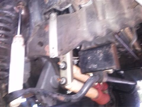1992 Ford Bronco - Close-up of vehicle suspension parts, including a shock absorber and sway bar.