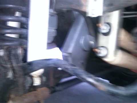 1992 Ford Bronco - Undercarriage view showing suspension components, including a coil spring and various linkages.