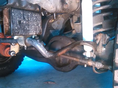1992 Ford Bronco - Close-up of the undercarriage, showing suspension components and the differential, illuminated by blue light.