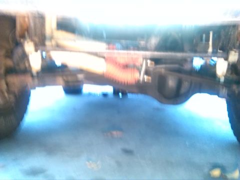 1992 Ford Bronco - The underside of a vehicle is shown, focusing on the rear axle and suspension system.