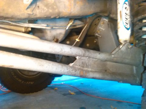 1992 Ford Bronco - Close-up of vehicle undercarriage, including suspension and tire. Text 'SUPERMOTORS' is visible.