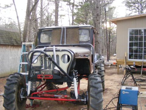 Modified off-road vehicle with large tires and roll cage