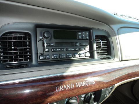 2004 Mercury Grand Marquis - The interior of a 2004 Mercury Grand Marquis features wood grain trim and a standard radio.