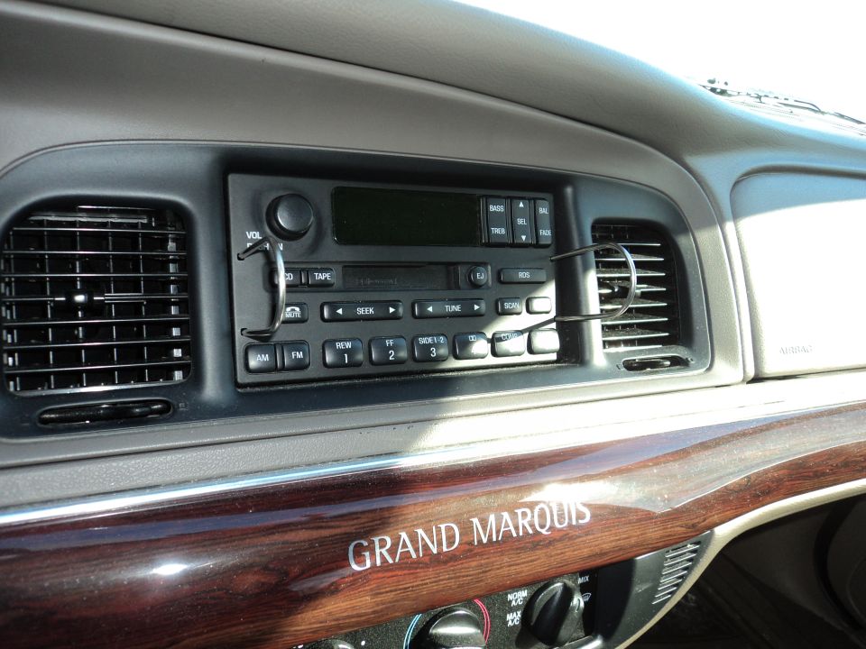 Dashboard of a 2004 Mercury Grand Marquis showing the radio and wood trim