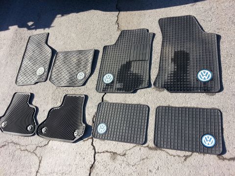 2002 Volkswagen Jetta - Several Volkswagen rubber floor mats are laid out on a concrete surface.