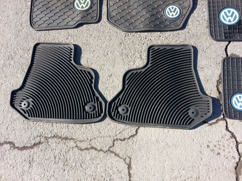 2002 Volkswagen Jetta - Close-up of multiple Volkswagen branded rubber floor mats laid out on a textured surface.