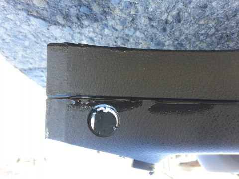 2002 Volkswagen Jetta - A close-up view of a black plastic automotive part with a circular cutout and visible wear.