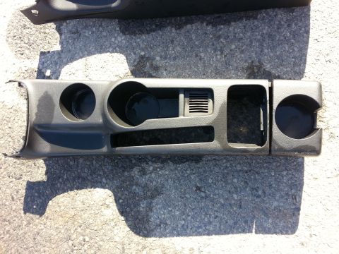 2002 Volkswagen Jetta - Center console trim piece with cup holders and air vent removed from a car.