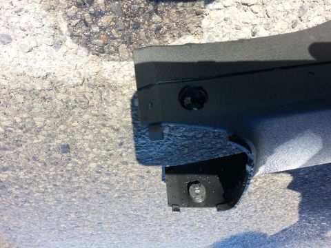 2002 Volkswagen Jetta - A detached piece of car interior trim is shown against a rough asphalt background.