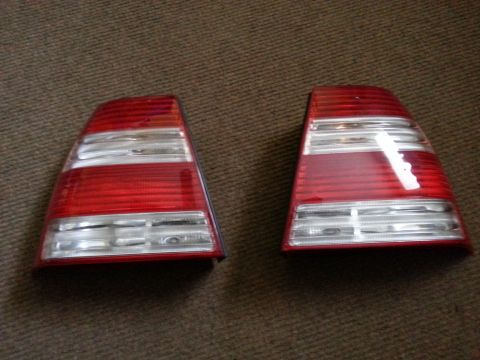 2002 Volkswagen Jetta - A pair of red and clear tail lights are displayed on a textured brown surface.