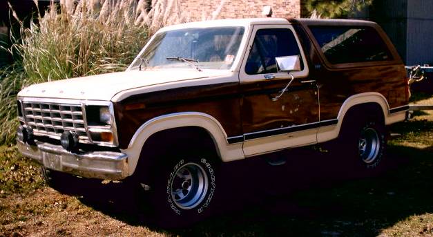 Ford Bronco with wood paneling on the side. Front grille has horizontal bars