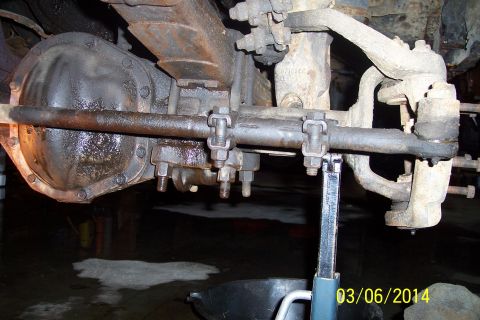 1973 Ford F-250 - The underside of a truck shows its rear axle assembly and suspension components, with a jack holding it up.