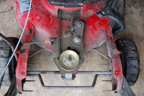 2006 Honda RANCHER - Close-up of a lawn mower's drive belt system and deck, with one wheel visible.