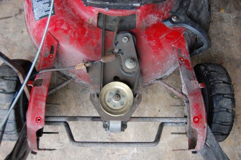 2006 Honda RANCHER - Close-up view of the drive belt and pulley system on a red lawn mower.