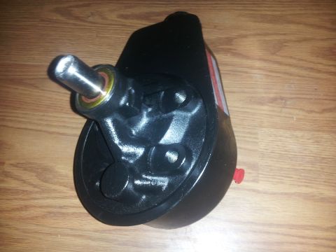 1988 Ford Bronco - A power steering pump sits on a wooden surface.