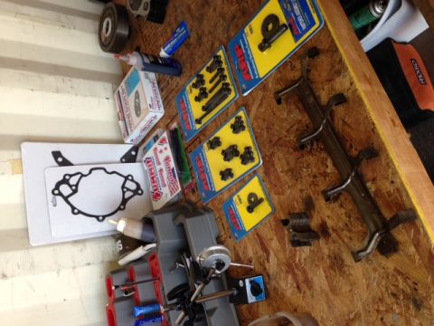 1996 Ford Bronco - Various engine parts, including gaskets and hardware, are organized on a workbench.
