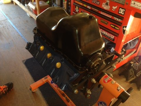 1996 Ford Bronco - An engine block sits on an orange stand, ready for installation or repair, with a tool chest in the background.