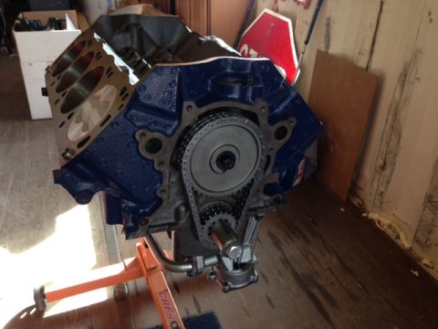 1996 Ford Bronco - Engine block assembly with timing chain and gears visible, mounted on an orange stand.