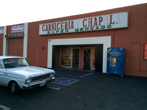 1964 Ford Ranchero - A white 1964 Ford Ranchero is parked in front of Carniceria Super Mercado.