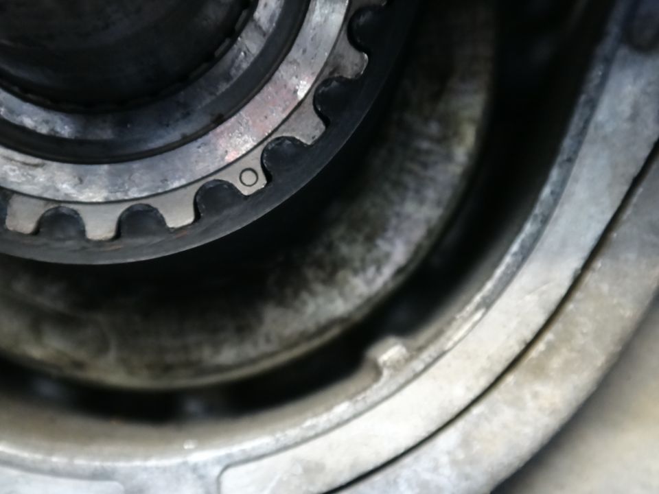 Close-up of a toothed timing belt pulley and metal housing