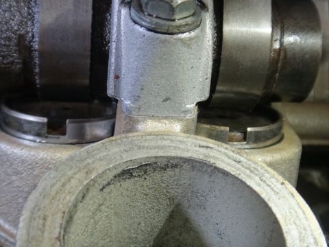 1993 Ford Taurus - A detailed view of an engine component, showing intricate metalwork and a bolt securing parts together.