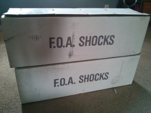1986 Ford Bronco - Two boxes labeled "F.O.A. SHOCKS" are stacked on a carpeted surface.