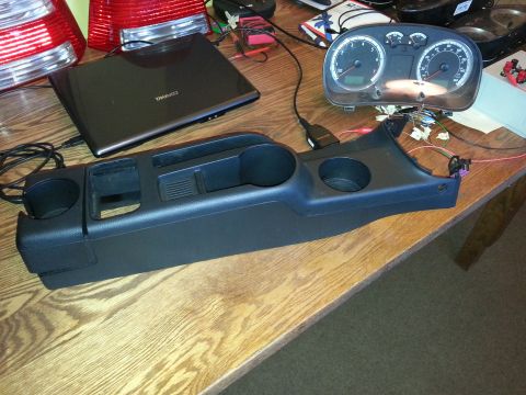2002 Volkswagen Jetta - Dashboard gauges and center console components, likely from a 2002 Volkswagen Jetta, are laid out on a table.