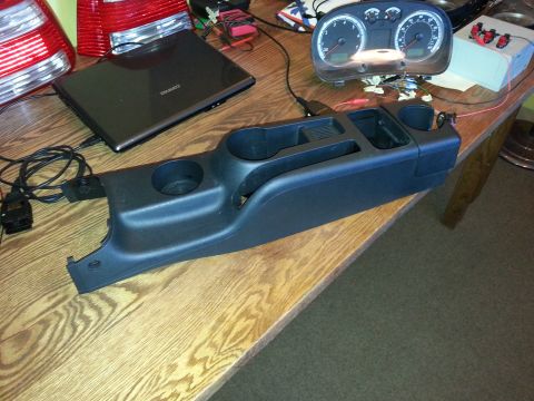 2002 Volkswagen Jetta - Car parts including a center console and instrument cluster are laid out on a table.