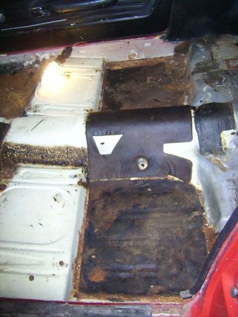 1968 Ford Mustang - The interior floor of a 1968 Ford Mustang shows extensive rust damage and deteriorated insulation.