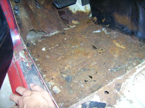 1968 Ford Mustang - Severe rust damage on the interior floor pan of a vehicle, indicating significant structural compromise.