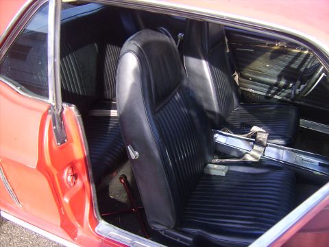 1968 Ford Mustang - Interior view of a 1968 Ford Mustang, highlighting the black vinyl seats and door trim.