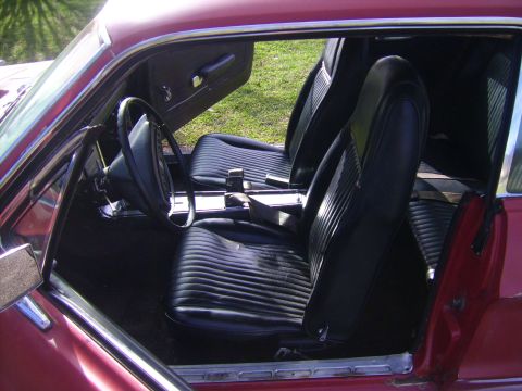 1968 Ford Mustang - Interior view of a 1968 Ford Mustang with black vinyl bucket seats and center console.