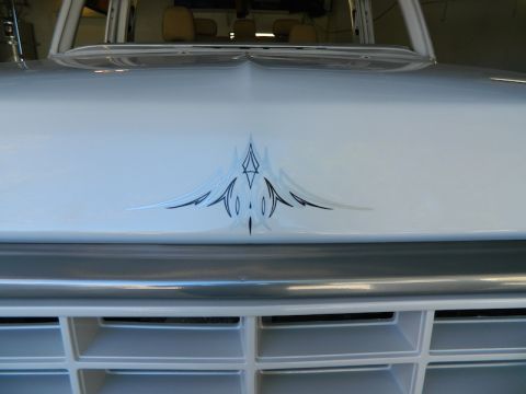 1979 Ford Bronco - Front view of a white truck a pinstripe decal on the hood and a chrome grille.