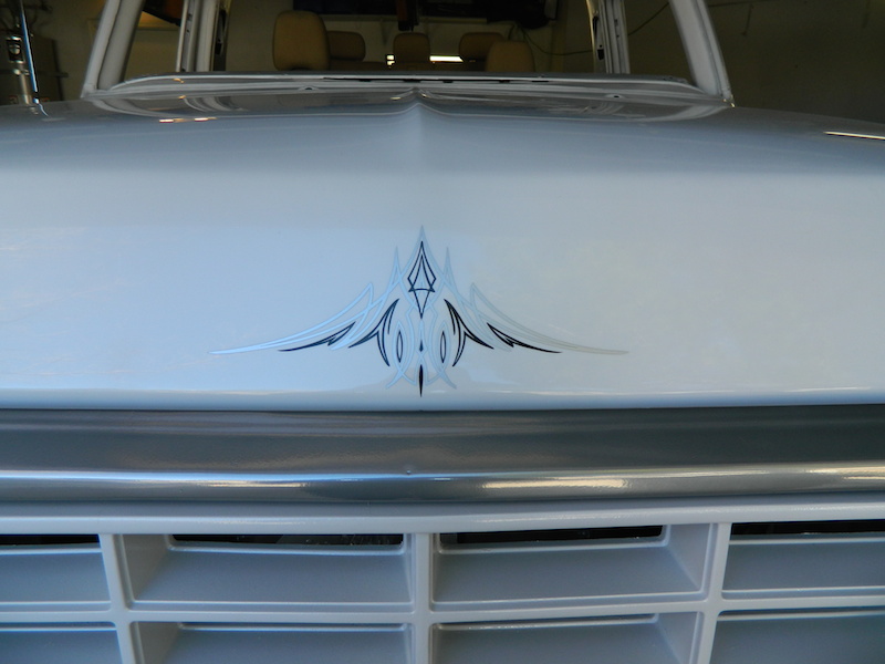 White truck hood with pinstripe decal and chrome grille