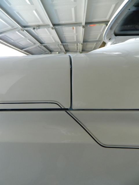 1979 Ford Bronco - Close-up view of white vehicle body panels showing a seam and pinstripe detail.