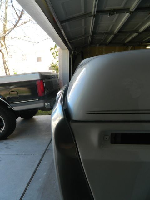 1979 Ford Bronco - The rear of a 1979 Ford Bronco is visible in a garage, parked alongside a black pickup truck.