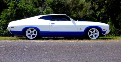 1964 Mercury Monterey - This two-door coupe features a white body with a blue lower accent and custom five-spoke wheels.