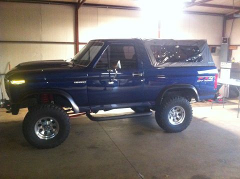 1982 Ford Bronco - This blue 1982 Ford Bronco features a soft top and an FX4 Off Road decal on the rear fender.