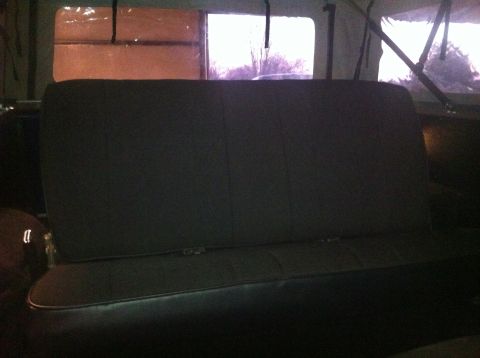 1982 Ford Bronco - Interior view of a vehicle's rear seat, with a glimpse of the outdoors through the back windows.