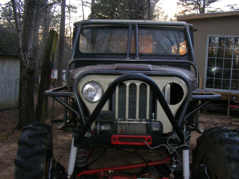 Modified jeep with large tires, winch, and roll cage, front view