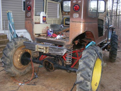 Rear view of a heavily modified vehicle with large tractor tires and a custom bumper