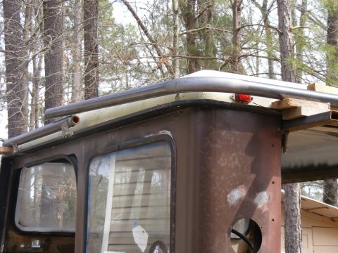 rusted side panel and roof rack on an old vehicle, trees in background