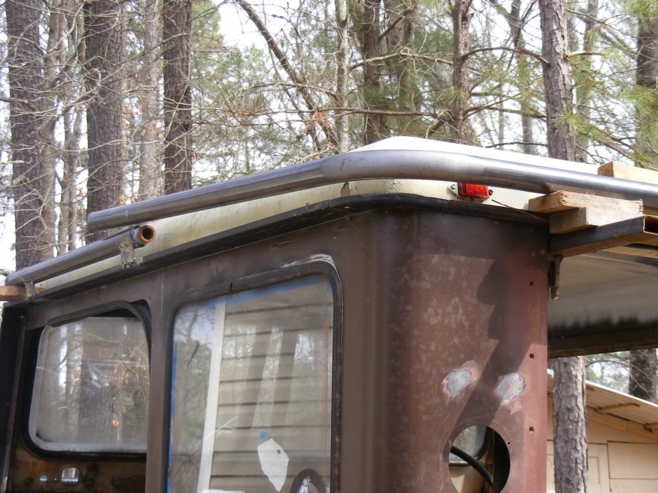 rusted side panel and roof rack on an old vehicle, trees in background