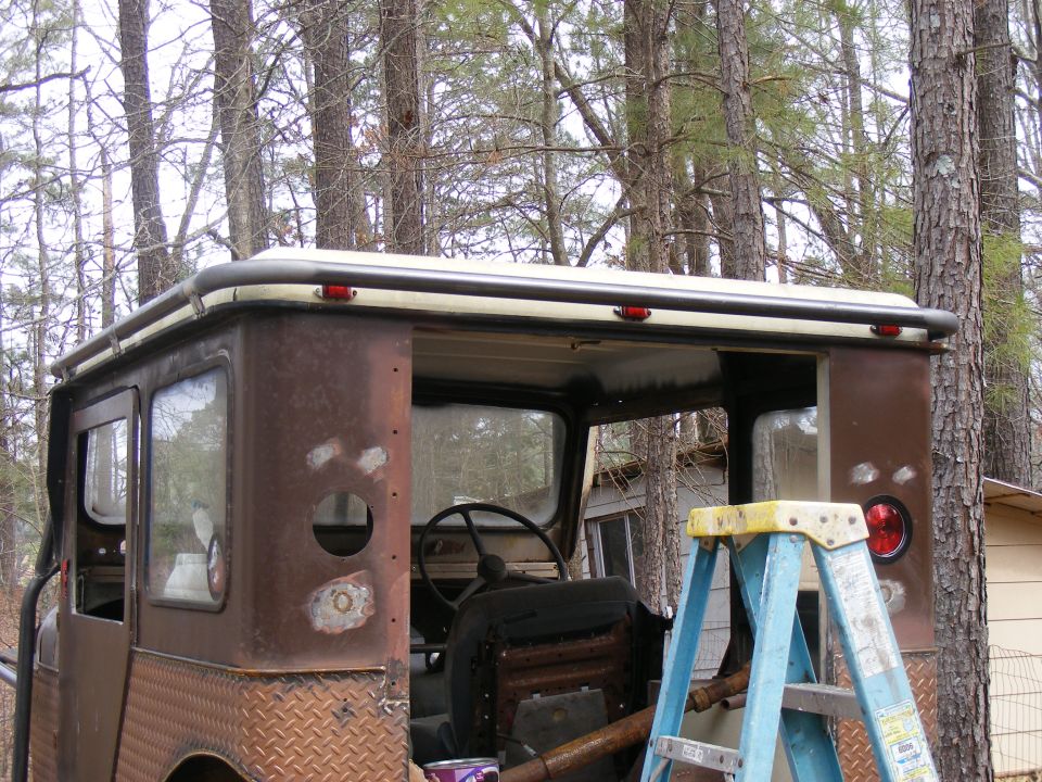 Rusted off-road vehicle with diamond plate rear quarter panels and a roof rack