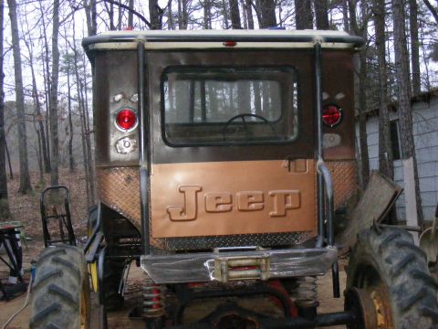 Jeep tailgate with raised lettering, diamond plate accents, and a winch bumper
