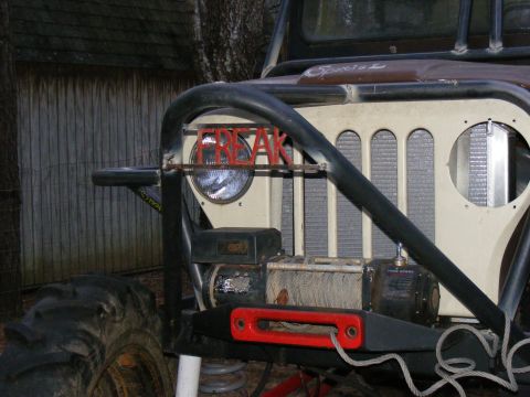 Modified Jeep CJ front end with "FREAK" letters on grille, winch, and large tires