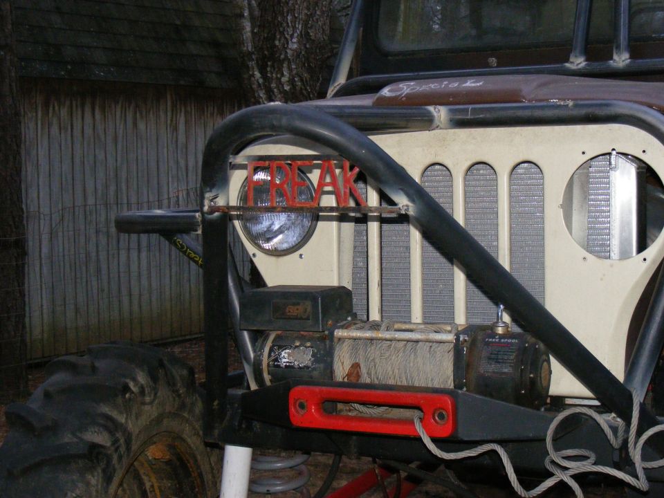 Modified Jeep CJ front end with "FREAK" letters on grille, winch, and large tires