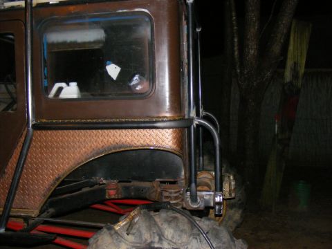 Modified off-road vehicle rear quarter panel with diamond plate fender flare and roll cage tubing