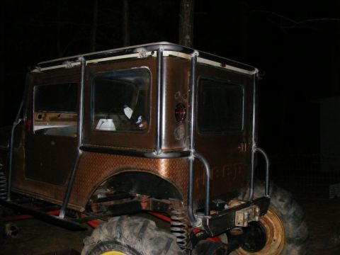 Modified Jeep CJ-5 with custom roll cage and diamond plate fenders, seen from the rear